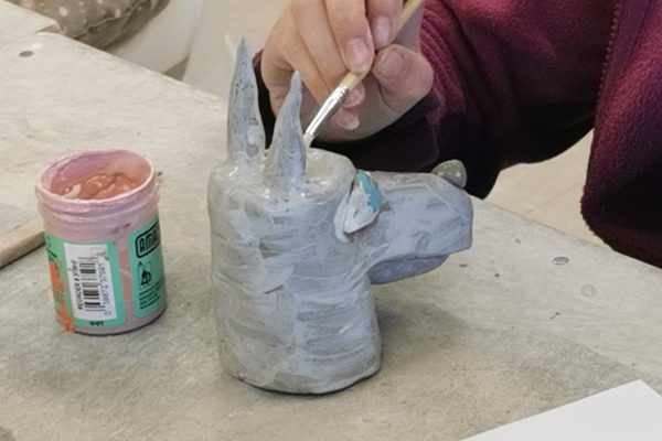 Member creating a dog from clay